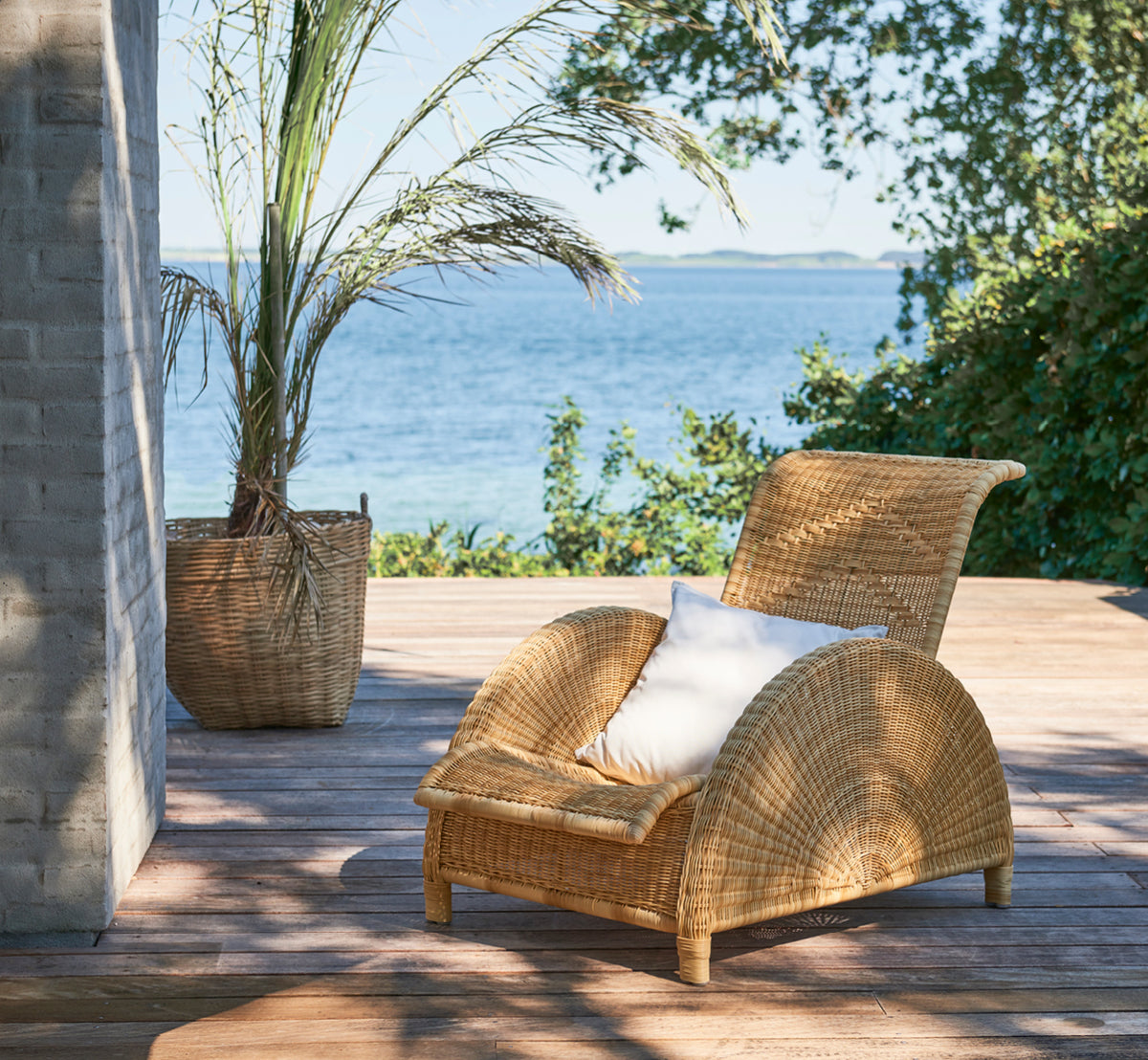 Esta es una imagen de estilo de vida de Paris sillón lounge exterior en natural core weave artfibre aluminium. Estilizado en un interior luminoso.