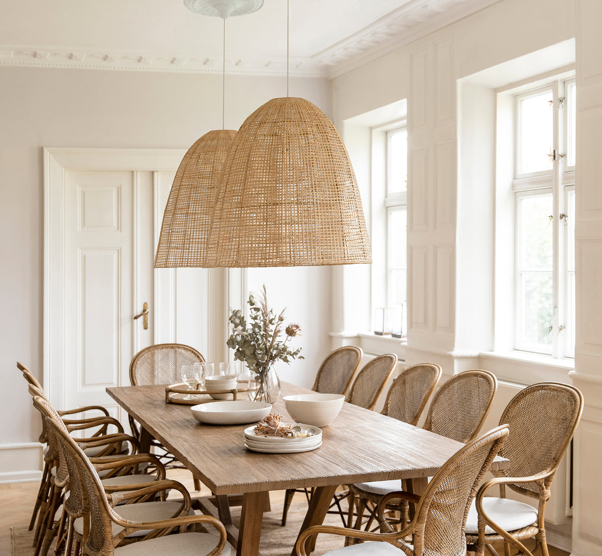 Esta es una imagen de estilo de vida de Showroom pantalla de lámpara en natural core weave artfibre & aluminium. Colgada sobre una mesa de comedor puesta en una habitación luminosa.