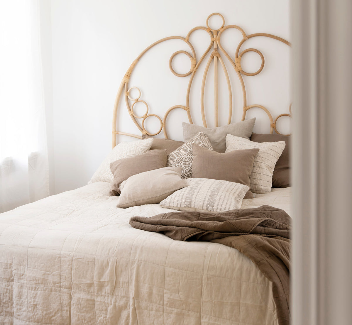 Esta es una imagen de estilo de vida de CTE058LA colcha en latte Cotton, en un dormitorio sereno con decoración neutra y parqué en espiga.