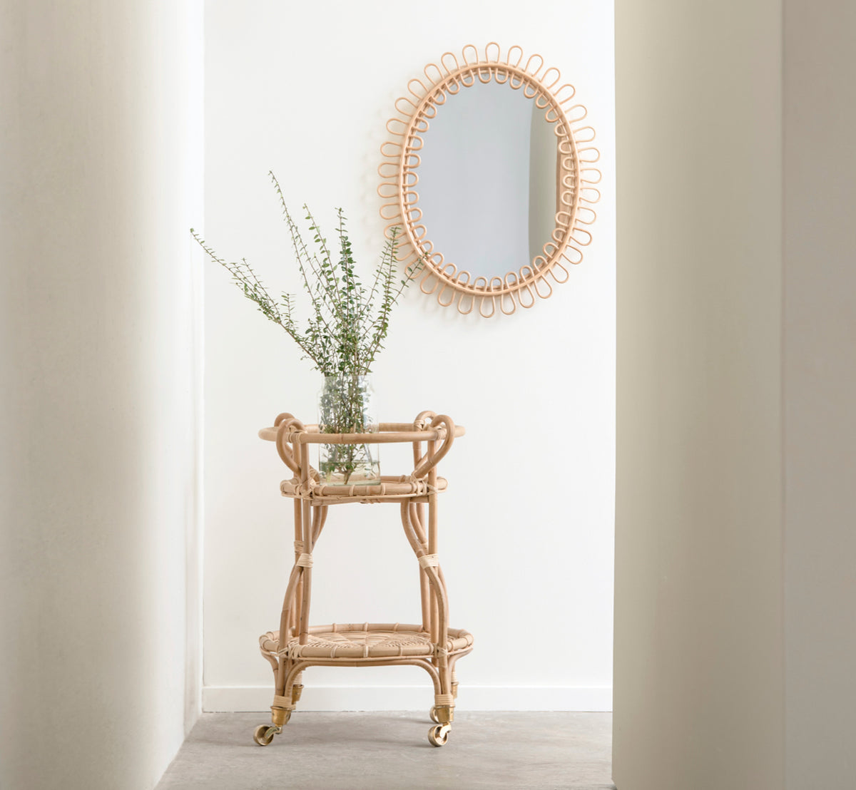 Esta es una imagen de estilo de vida de Fratellino carrito en polished Natural Rattan, en un interior clásico con elaboradas puertas de paneles.