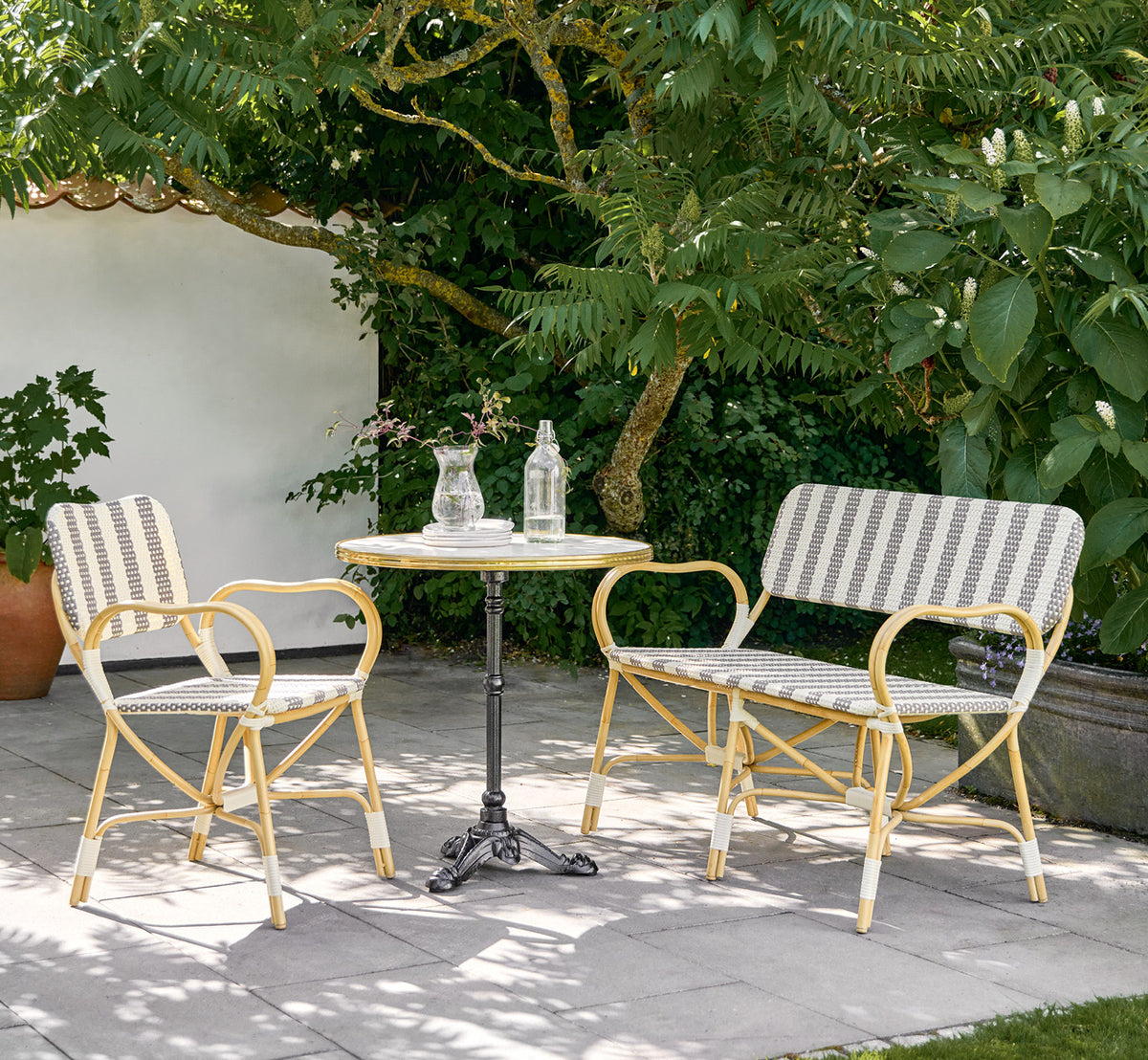 Esta es una imagen de estilo de vida de Bistro Exterior silla en natural Aluminium ArtFibre, en un café de jardín al aire libre con una mesa de.