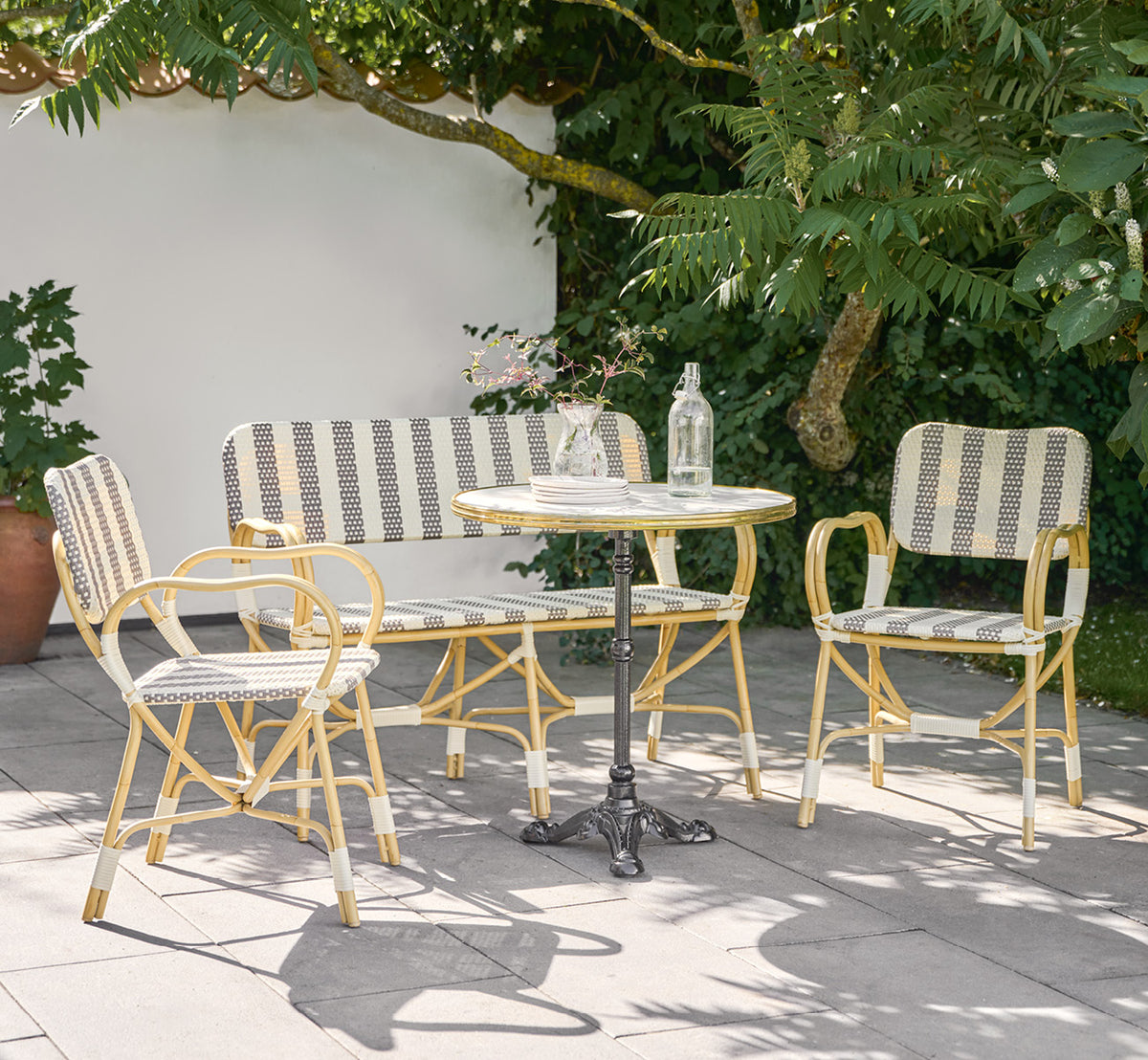 Esta es una imagen de estilo de vida de Bistro Exterior silla en natural Aluminium ArtFibre, en un café de jardín al aire libre con una mesa de.