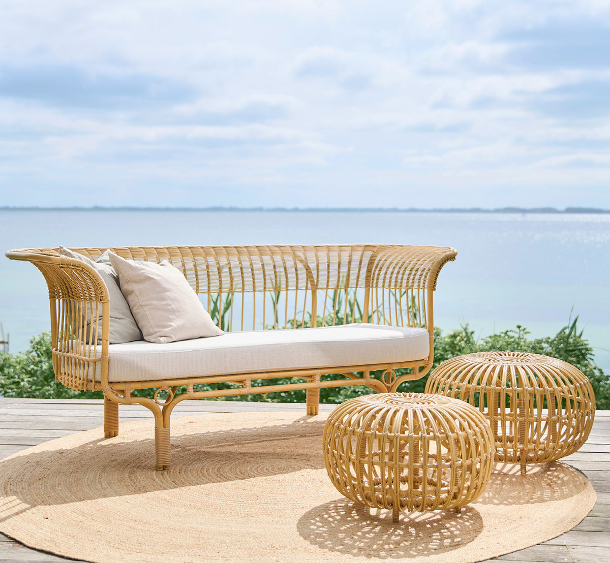 Esta es una imagen de estilo de vida de FA-E16-NU Ottoman Exterior en natural aluminium artfibre. Estilizado en un interior luminoso.
