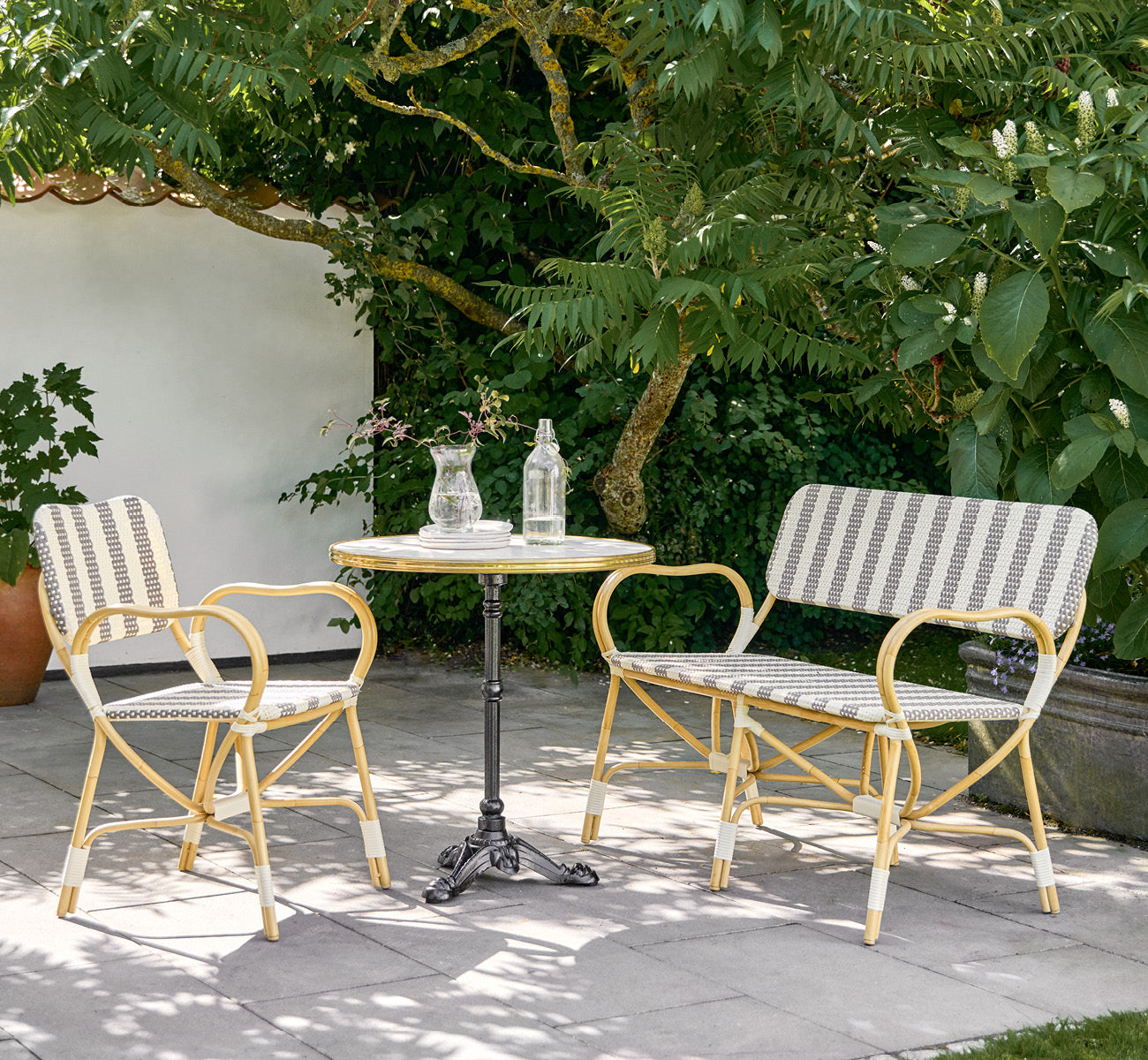 Esta es una imagen de estilo de vida de Bistro Exterior silla en natural Aluminium ArtFibre, en un café de jardín al aire libre con una mesa de.