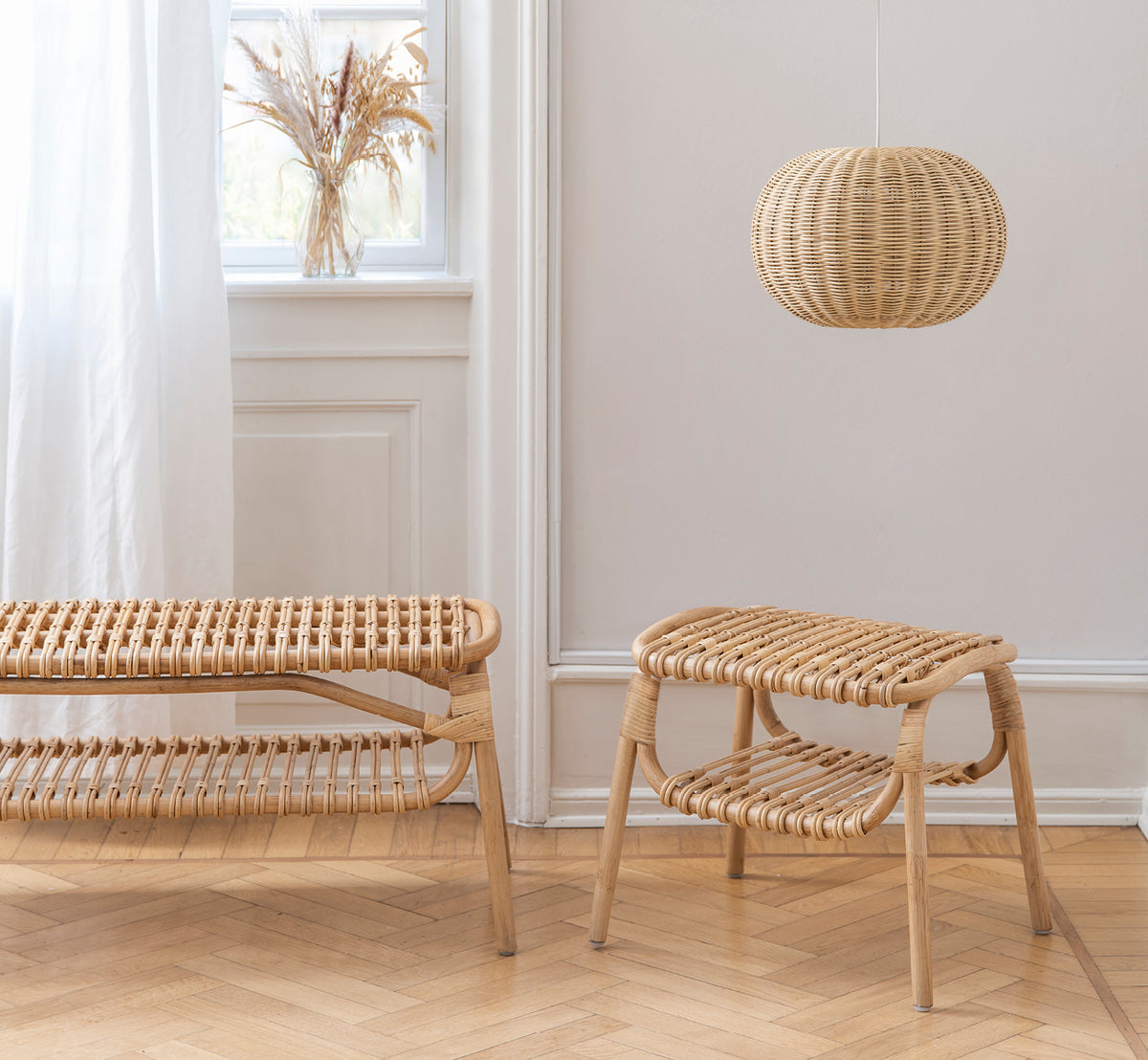 Esta es una imagen de estilo de vida de Machiya banco en natural skin on rattan. Sala escandinava con taburete, lámpara colgante y jarrón con hierba de las pampas.