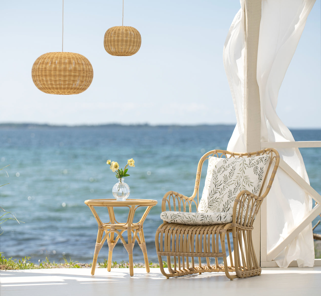 Esta es una imagen de estilo de vida de Tulip sillón lounge exterior en natural aluminium artfibre. Estilizado en un interior luminoso.