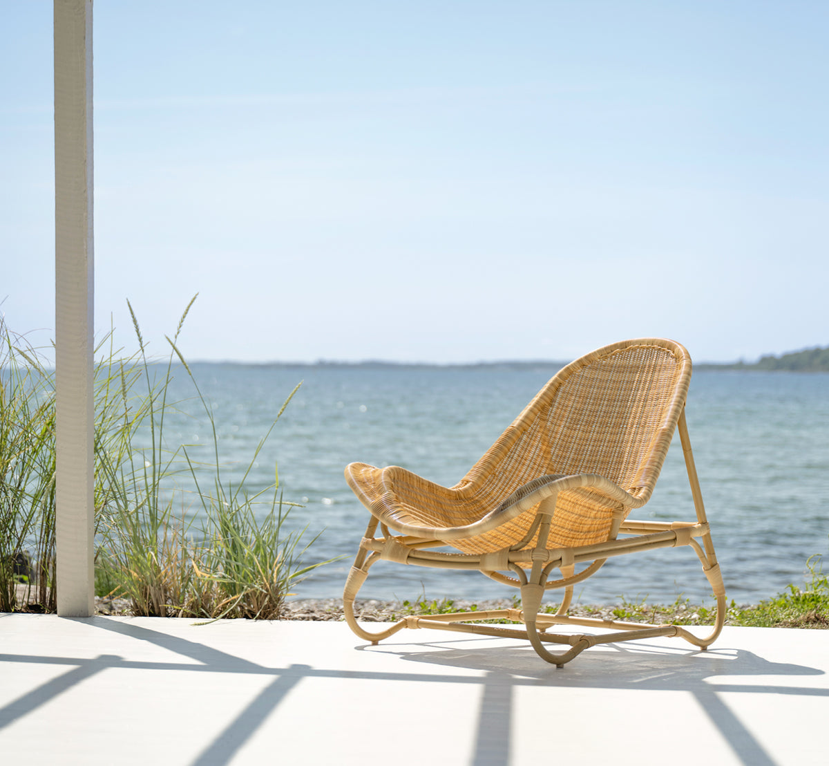 Esta es una imagen de estilo de vida de Pacifique sillón lounge exterior en natural core weave artfibre aluminium. Estilizado en un interior luminoso.