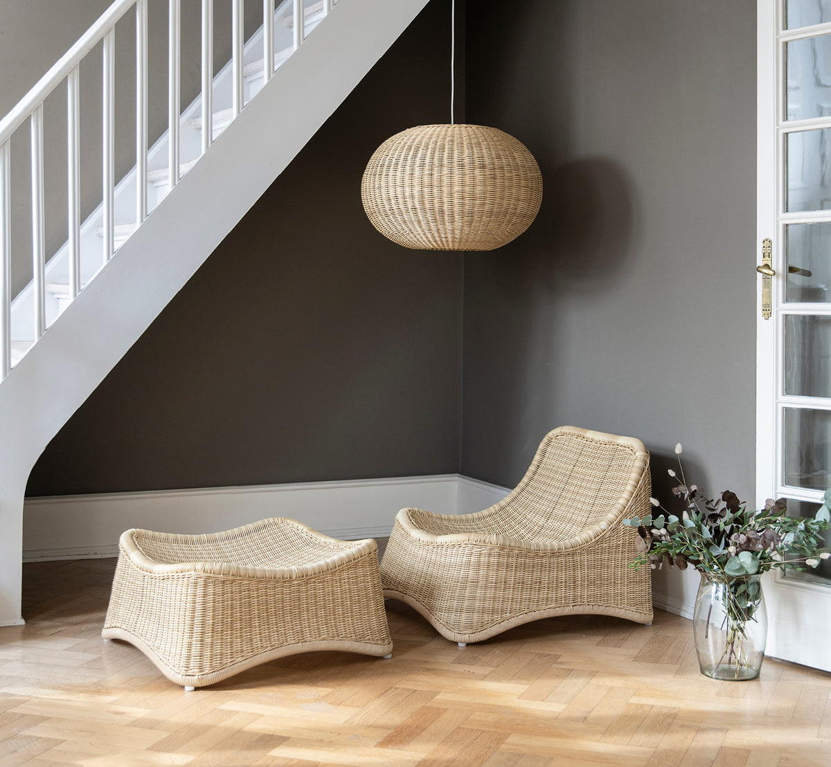 Esta es una imagen de estilo de vida de Chill sillón lounge en natural core weave Rattan frame, en un elegante interior clásico con elaboradas.