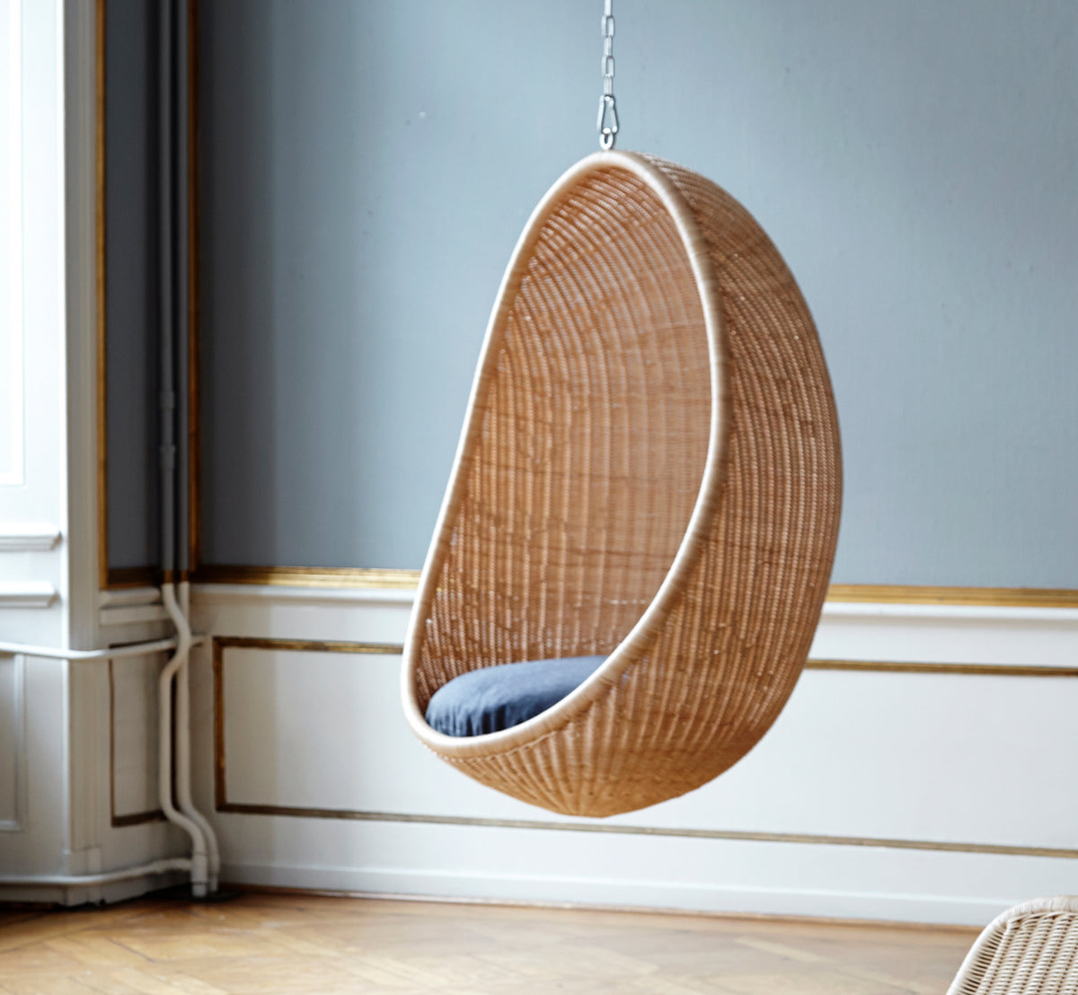 Esta es una imagen de estilo de vida de Hanging silla colgante en natural core weave Rattan frame, en un elegante interior clásico con elaboradas.