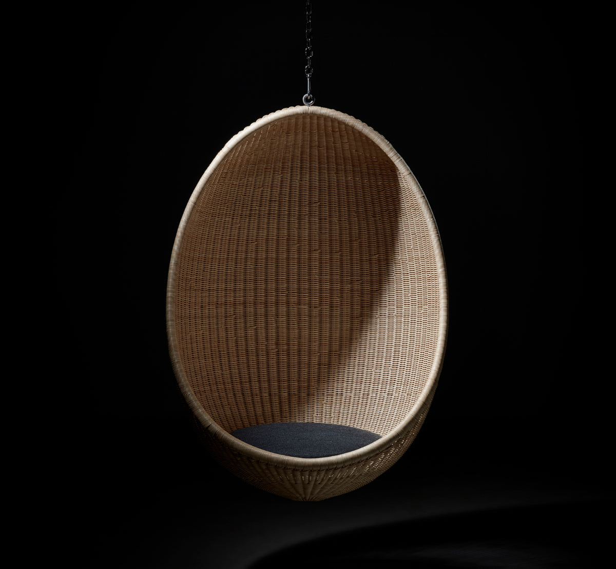 Esta es una imagen de estilo de vida de Hanging silla colgante en natural core weave Rattan frame, en un elegante interior clásico con elaboradas.