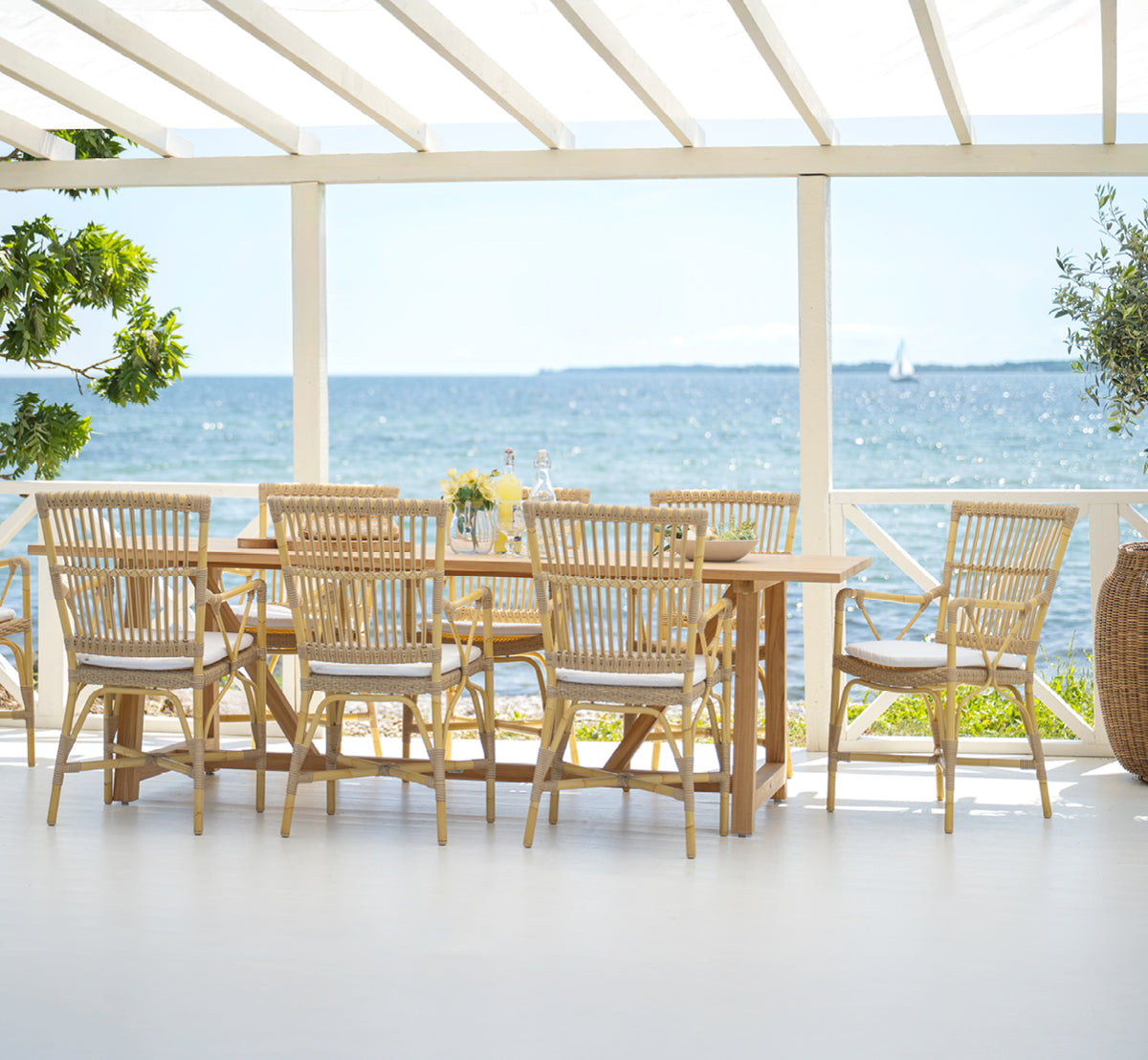 Esta es una imagen de estilo de vida de Piano sillón de comedor exterior en natural aluminium artfibre. Estilizado en un interior luminoso.