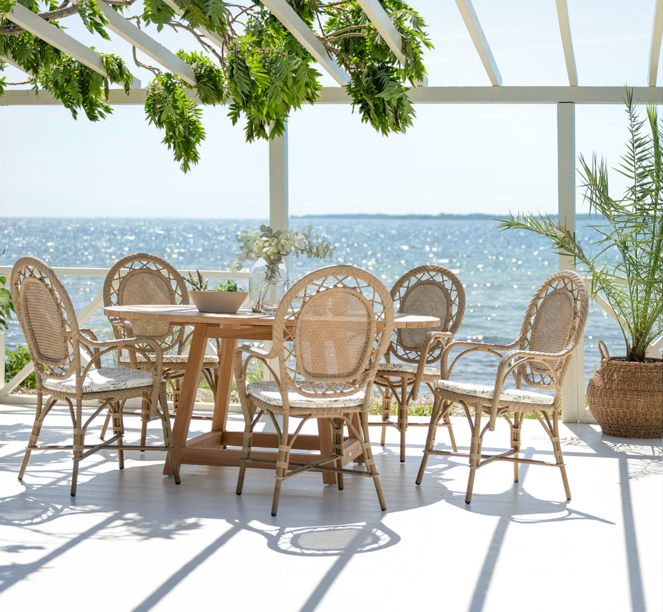 Esta es una imagen de estilo de vida de Romantica silla de comedor exterior en antique aluminium artfibre. Estilizado en un interior luminoso.