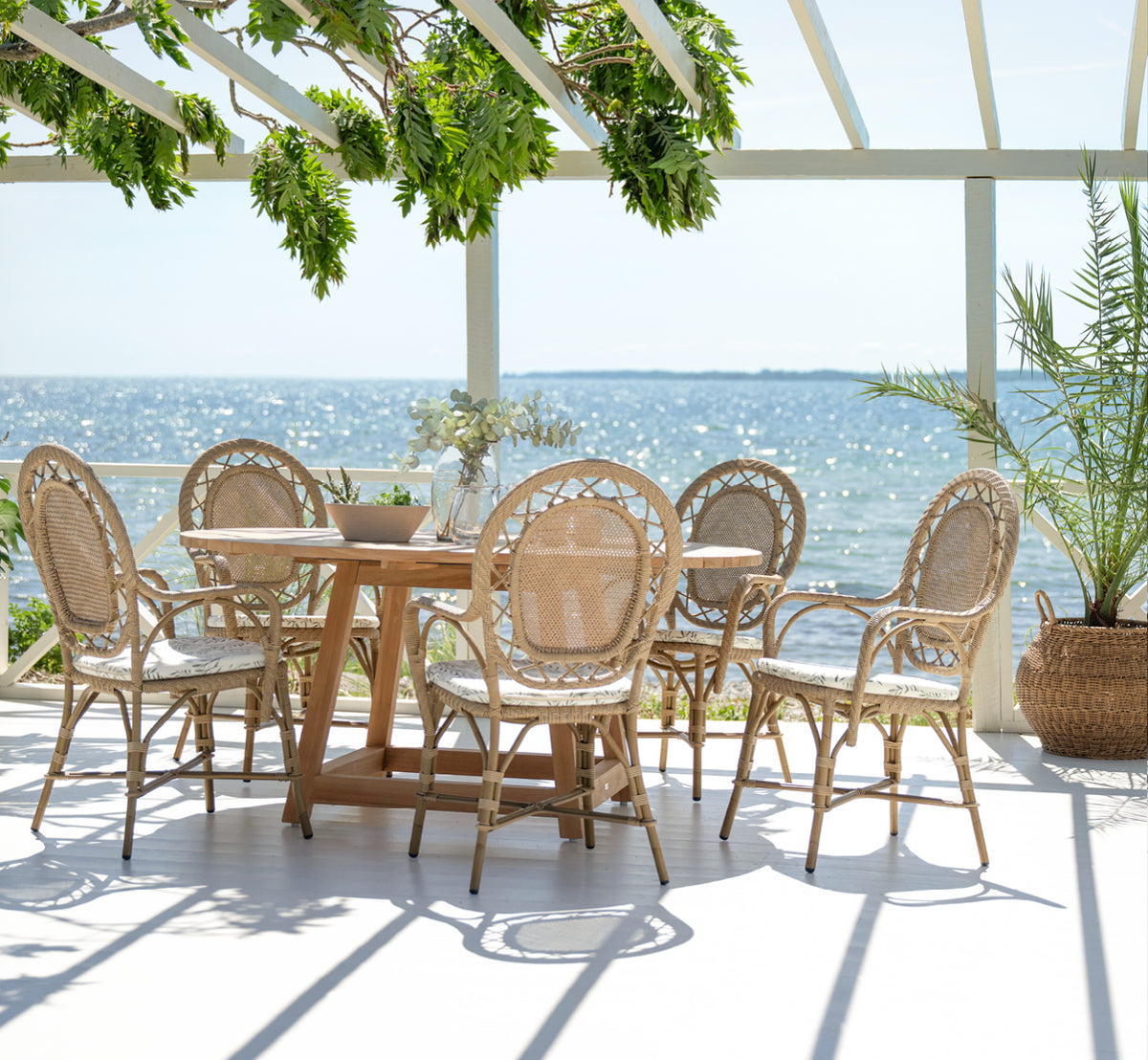 Esta es una imagen de estilo de vida de Romantica silla de comedor exterior en antique aluminium artfibre. Estilizado en un interior luminoso.