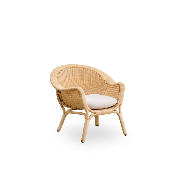 Vista lateral de la silla de lounge exterior Madame, diseñada por Nanna & Jørgen Ditzel. Silla de lounge completamente tejida en ratán con diseño suave y femenino en forma de concha.