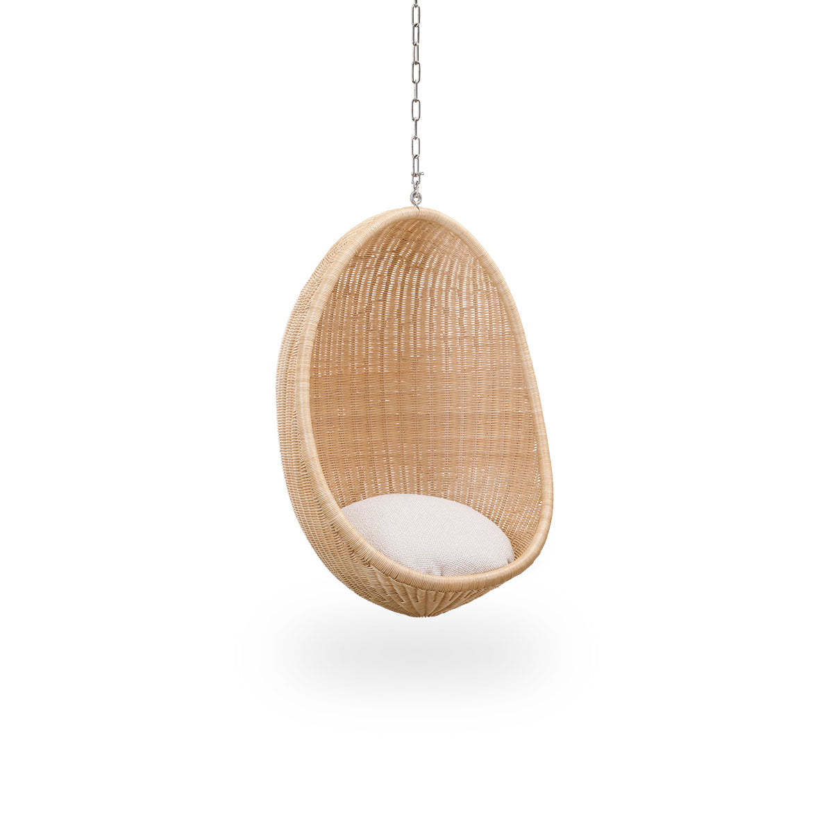 Vista lateral del Hanging Egg Junior, la versión infantil de la icónica silla colgante diseñada por Nanna y Jørgen Ditzel. La silla colgante redonda está completamente tejida con ratán indonesio de alta calidad y cuelga de una cadena metálica.