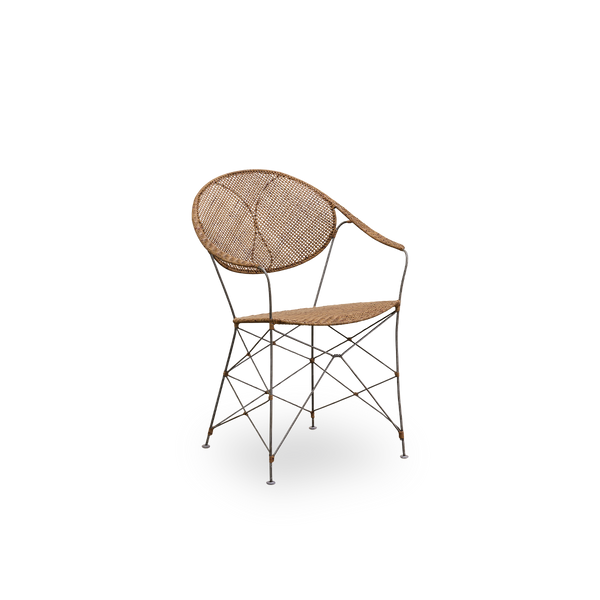 Vista lateral de la silla de comedor Funky, diseñada por Yuzuru Yamakawa. La silla tiene una estructura de acero con asiento y respaldo tejidos a mano en ratán indonesio de alta calidad en color avellana.