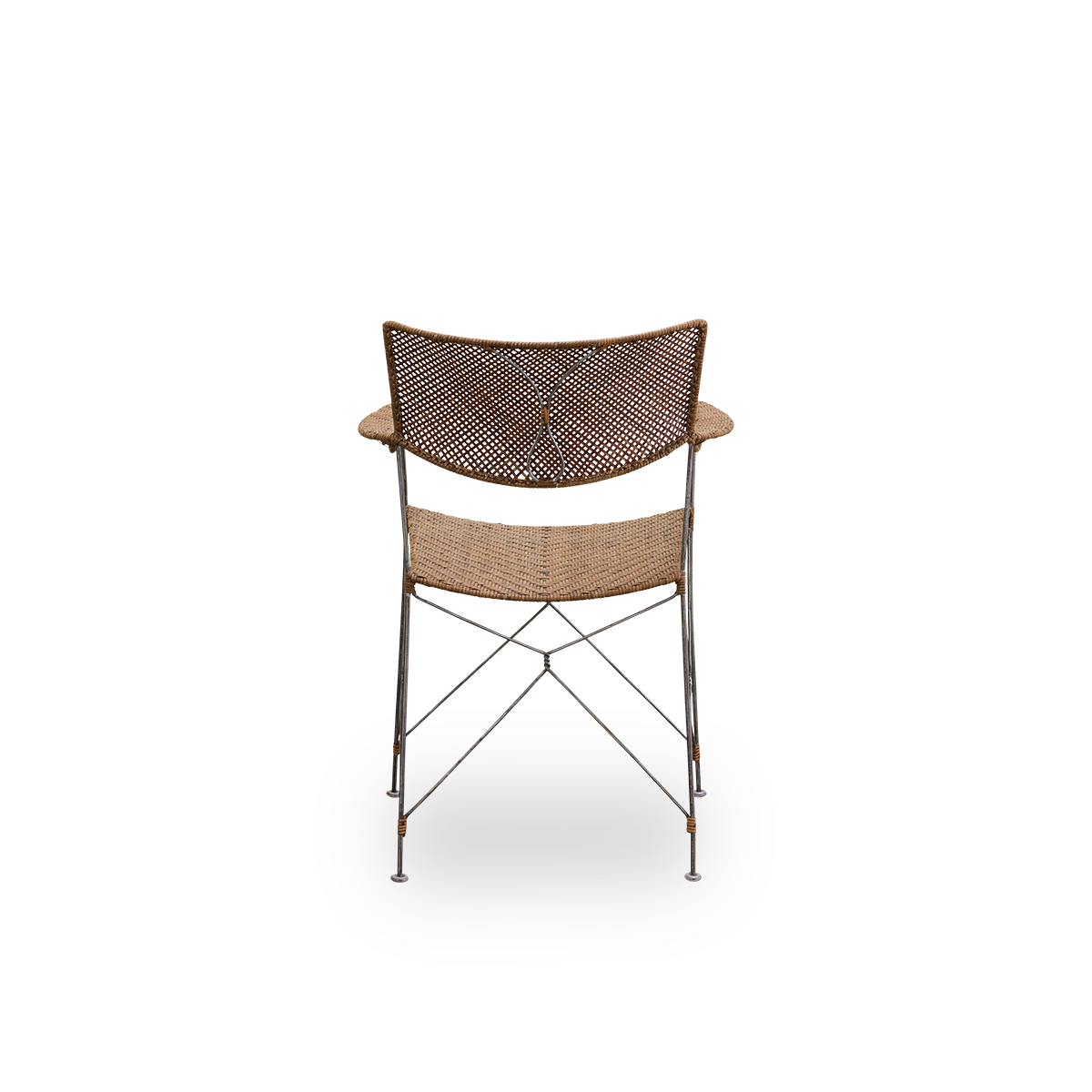 Vista desde atrás de la silla de comedor Rap, diseñada por Yuzuru Yamakawa. Estructura de acero con asiento y respaldo tejidos a mano en ratán indonesio. Silla ligera que combina el diseño japonés con la artesanía tradicional indonesia.