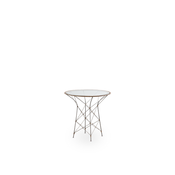 Vista lateral de la mesa de café Funky, diseñada por Yuzuru Yamakawa. La mesa tiene un tablero redondo de vidrio y una estructura de acero tejida a mano con ratán indonesio en color avellana.